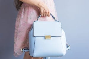 Close up stylish woman in pink skirt with blue bag. Fashion concept.